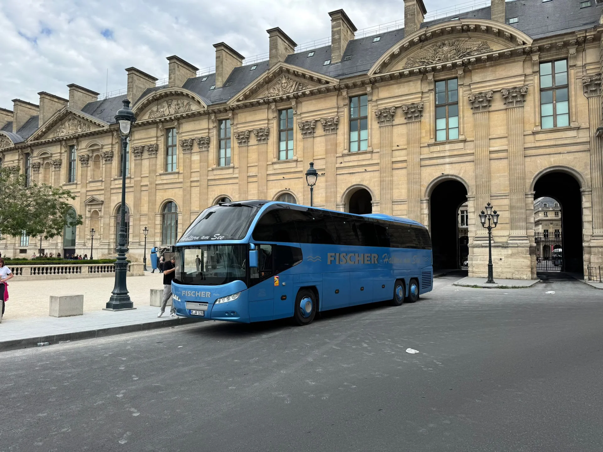 Blauer Fischer Reisebus vor einem historischen Stadtgebäude