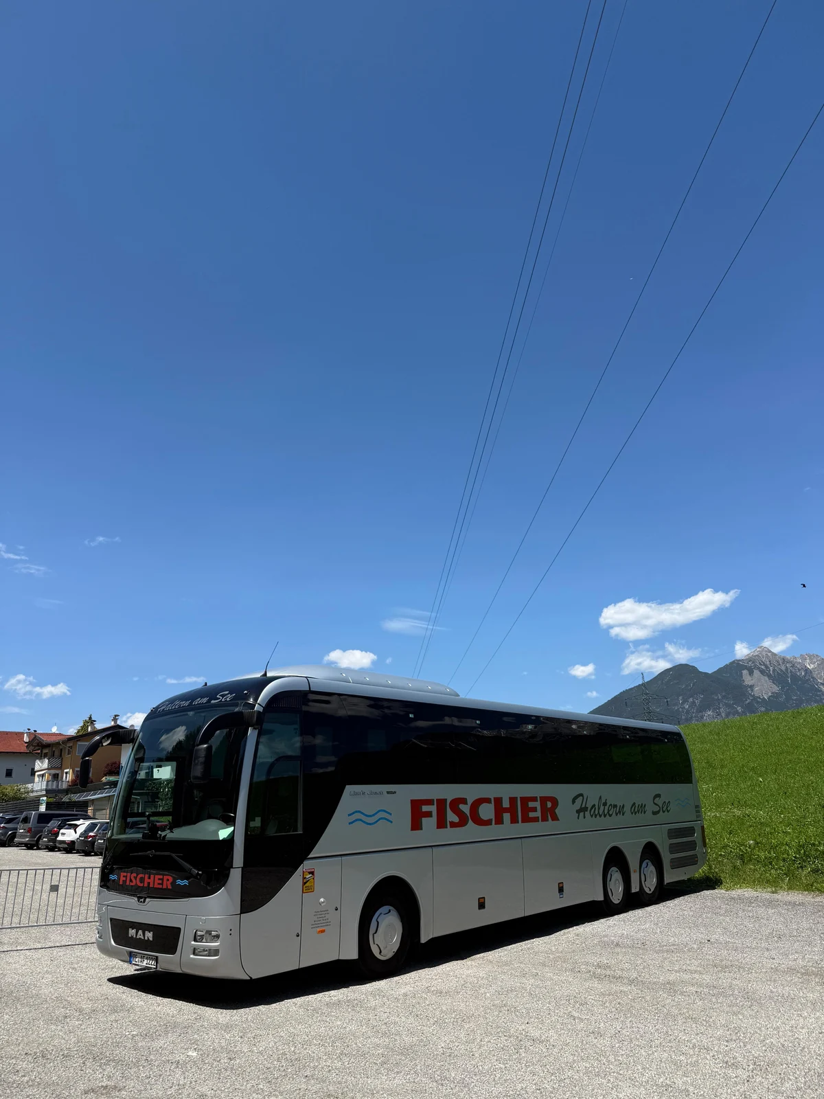 Weißer MAN Lion’s Coach von Fischer Bustouristik vor einer Berglandschaft