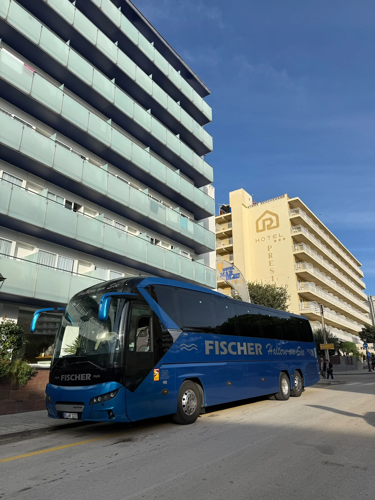 Blauer Neoplan Tourliner von Fischer Bustouristik vor Hotelgebäuden